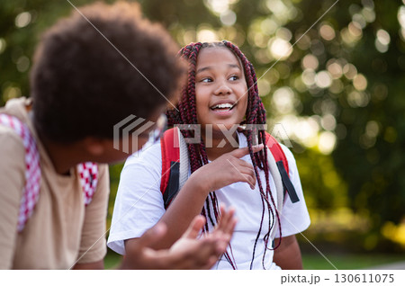 Teens sitting at the playground after school and talking Teens sitting at the playground after school and talking 130611075