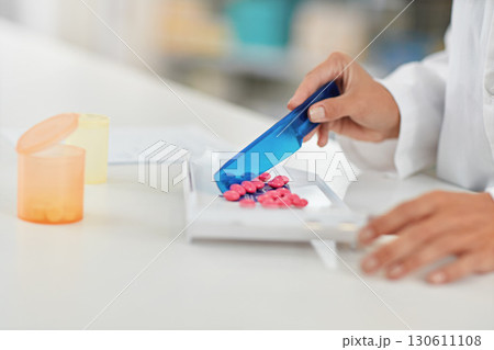 Hands, pharmacist and counting pills for drug dose, packaging or prescription at a pharmacy. Hand of doctor working with medication tablets or pharmaceutical drugs for healthcare on counter at clinic 130611108