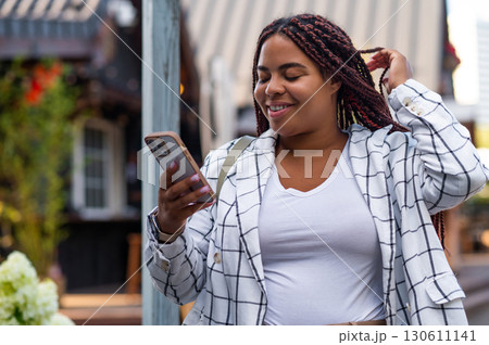 Female using smartphone standing in city background Female using smartphone standing in city background 130611141