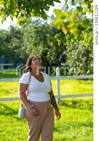Smiling plus size woman standing park in stylish outfit Smiling plus size woman standing park in stylish outfit 130611184