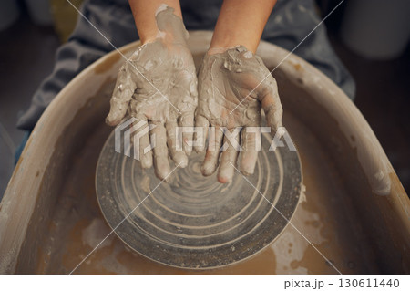 Hands, clay and pottery wheel in a workshop after creating a sculpture or project for a small business. Creative, crafts and artistic sculptor manufacturing handicraft mould products in an art studio 130611440