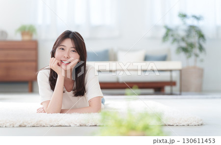 床に寝転ぶ笑顔の女性 130611453