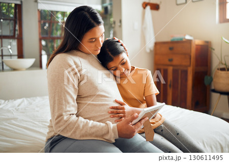 Pregnant mom and child look at a picture frame together in the bedroom of their modern house. Sad, emotional and mother with pregnancy holding her girl kid while looking at a photo on the bed at home Pregnant mom and child look at a picture frame together in the bedroom of their modern house. Sad, emotional and mother with pregnancy holding her girl kid while looking at a photo on the bed at home 130611495