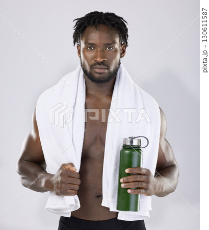 Black man, exercise and portrait with towel and water bottle for sports training in studio. Health and wellness of a sexy male bodybuilder model with ready for fitness workout, goals and strong body 130611587