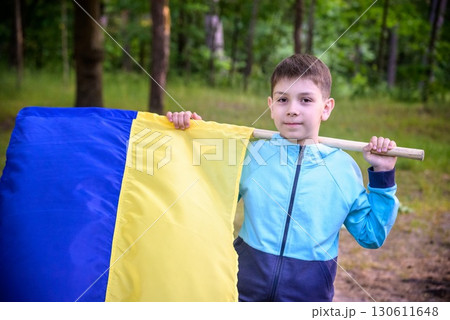 Ukrainian boy with waving flag and praying to stop the war in Ukraine in a field at sunset. War of Russia against Ukraine. Stop War Ukrainian boy with waving flag and praying to stop the war in Ukraine in a field at sunset. War of Russia against Ukraine. Stop War 130611648