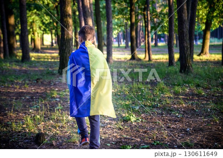 Worried teenager patriot wear blue yellow Ukrainian flag on his shoulders. Spring nature background. Ukraine national symbol. Patriotism Worried teenager patriot wear blue yellow Ukrainian flag on his shoulders. Spring nature background. Ukraine national symbol. Patriotism 130611649