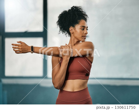 Fitness, black woman or girl in gym stretching arms to warm up body or relax muscles for workout exercise. Wellness, focus or healthy sports athlete ready to start training or exercising in Atlanta 130611750