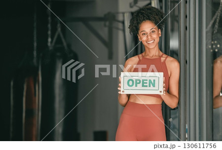 Fitness, portrait or personal trainer at gym with an open sign for workout exercises or training. Manager, happy or healthy black woman with a friendly smile holding a board to welcome exercising 130611756