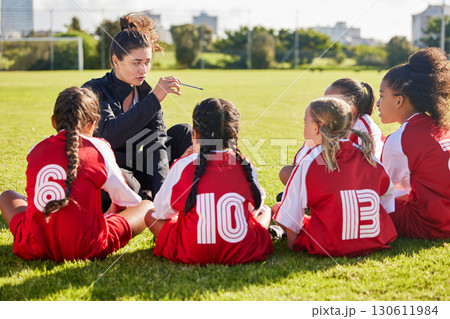 Coaching, exercise or coach with children for soccer strategy, training and team goals in Canada. Team building, teamwork and woman planning group of girl on football field for game, match or workout 130611984