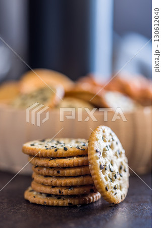 Crispy round salted crackers on black table. 130612040