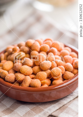 Peanuts in a crispy crust in bowl on checkered napkin. Peanuts in a crispy crust in bowl on checkered napkin. 130612052