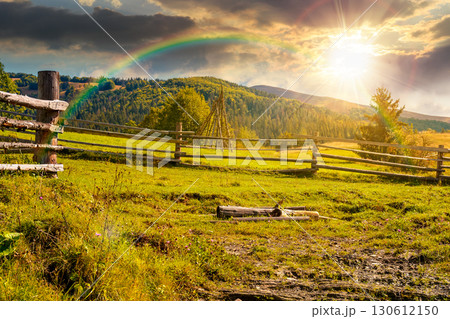 mountainous rural landscape in autumn at sunset. wooden fence near the path through grassy meadow on the hillside. scenery with fir forest on the mountains in evening light under sky with clouds mountainous rural landscape in autumn at sunset. wooden fence near the path through grassy meadow on the hillside. scenery with fir forest on the mountains in evening light under sky with clouds 130612150
