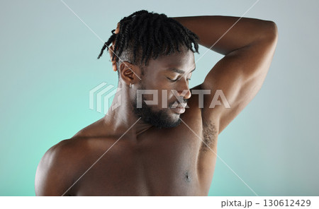 Armpit, wellness and black man with skincare hygiene or grooming isolated against a studio background. Natural, cosmetics and body care for healthy skin by a young, confident and African model Armpit, wellness and black man with skincare hygiene or grooming isolated against a studio background. Natural, cosmetics and body care for healthy skin by a young, confident and African model 130612429