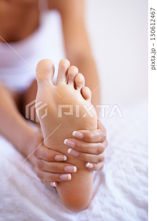 Foot, hands and massage with a woman on a bed in her home in the morning after waking up from rest. Feet, hand or stretching with a female in her bedroom to relax while massaging her sole in a house Foot, hands and massage with a woman on a bed in her home in the morning after waking up from rest. Feet, hand or stretching with a female in her bedroom to relax while massaging her sole in a house 130612467