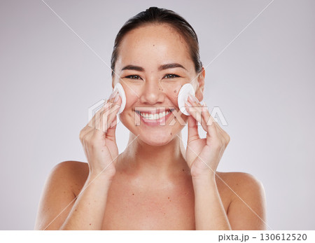 Face portrait, skincare cotton and Asian woman in studio isolated on a gray background. Makeup hygiene, beauty dermatology and happy female model with facial pad or product for cleaning cosmetics. 130612520