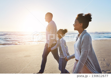 Black family, sunset and walking on the beach by happy child and parents on vacation or holiday. Sea, ocean and travel with African daughter or kid holding hands together near water 130612677