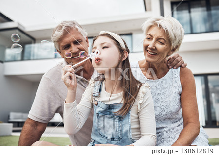 Smile, family and girl with bubbles and grandparents enjoying weekend, holiday and quality time together. Love, home and happy girl, grandmother and grandfather bonding, relaxing and fun in garden 130612819