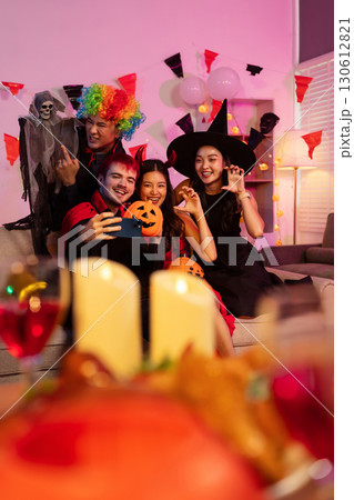 Dinner and group of people celebrating together at Halloween party. 130612821