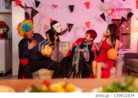Dinner and group of people celebrating together at Halloween party. 130612834