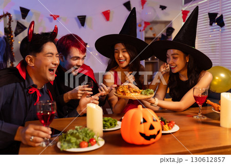 Dinner and group of people celebrating together at Halloween party. 130612857