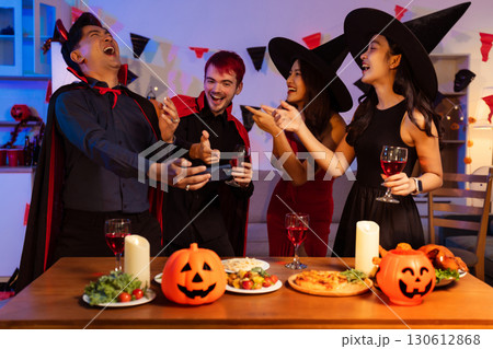 Dinner and group of people celebrating together at Halloween party. Dinner and group of people celebrating together at Halloween party. 130612868
