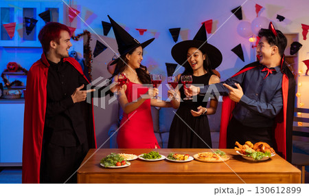 Dinner and group of people celebrating together at Halloween party. 130612899