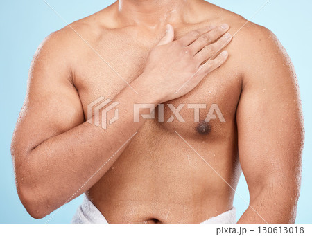 Skin, body and man after skincare shower or bath for hygiene and wellness isolated against a blue background. Topless, clean and muscles of fit male doing self care cosmetic routine 130613018