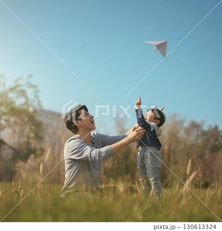 紙飛行機を飛ばす親子 紙飛行機を飛ばす親子 130613324