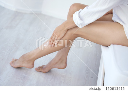 Skincare, beauty and hair removal with legs of woman in bedroom for wellness, self care and pedicure. Shaving, waxing and epilation with girl on bed at home for cosmetics, glow and clean treatment 130613413