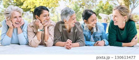 Senior women, friends and relax on picnic in park for bonding, wellness and rest on blanket. Happiness, comic and group of elderly people in retirement talking, laughing and enjoying time in nature. 130613477
