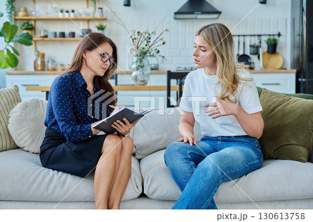 Female social worker working at home with young woman Female social worker working at home with young woman 130613758