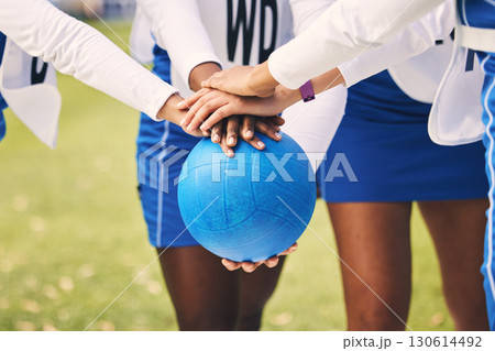 Sports, netball and team in a huddle with a ball for game strategy planning, motivation or pride. Fitness, diversity and female athletes with a stack of hands for collaboration on field before match. Sports, netball and team in a huddle with a ball for game strategy planning, motivation or pride. Fitness, diversity and female athletes with a stack of hands for collaboration on field before match. 130614492