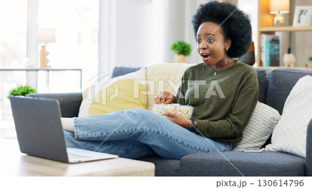 Popcorn, surprise and black woman with a laptop, movie and connection with network, relax and fun on a weekend. African person, home and girl on a couch, cinema snack and streaming a film with shock Popcorn, surprise and black woman with a laptop, movie and connection with network, relax and fun on a weekend. African person, home and girl on a couch, cinema snack and streaming a film with shock 130614796