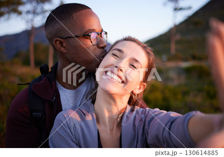 Interracial couple, kiss and smile for selfie, travel or love for adventure, journey or hiking together in nature. Happy man kissing woman smiling in happiness for photo moments, trip or traveling Interracial couple, kiss and smile for selfie, travel or love for adventure, journey or hiking together in nature. Happy man kissing woman smiling in happiness for photo moments, trip or traveling 130614885