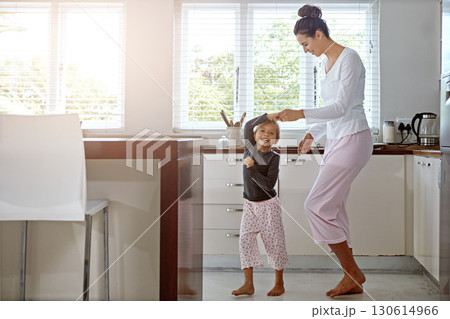 Kitchen dance, mom and girl in the morning at home with happiness dancing together. Mom, child and mama care holding hands with a young kid in a house happy about funny family with a smile Kitchen dance, mom and girl in the morning at home with happiness dancing together. Mom, child and mama care holding hands with a young kid in a house happy about funny family with a smile 130614966