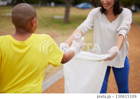 Recycle, sustainability and cleaning trash at a park outdoors by a young volunteer or kid with plastic bottle. Environment, earth day and charity activists to pickup pollution for climate change 130615109
