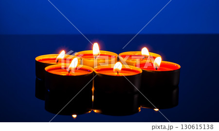 Burning small candles on a blue background Burning small candles on a blue background 130615138