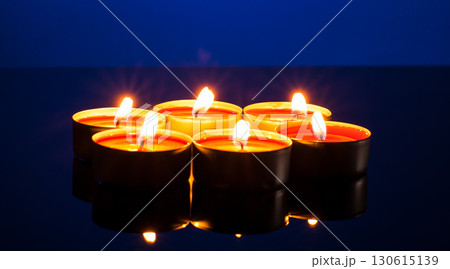 The darkness melts in the glow of dozens of candles 130615139