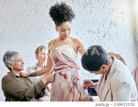 Designer women, model and fitting dress for focus, design or teamwork for runway fashion in workshop. Happy team, woman collaboration and success vision for diversity, goals or helping hand in studio 130615338