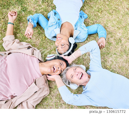 Top view, senior or people and music headphones in silent disco, retirement friends fun or bonding community wellness. Smile, happy or elderly women lying on nature park grass and listening to radio 130615772