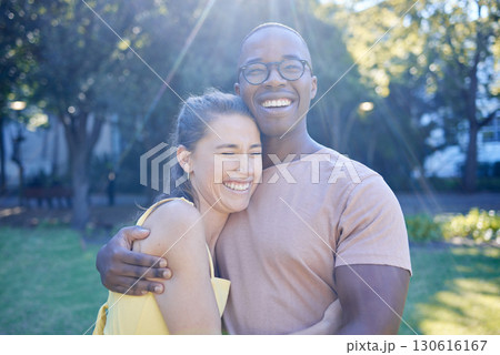 Happy interracial couple, hug and laughing in joy for bonding relationship together in the park. Man hugging woman smiling in happiness for love, embrace and sharing a laugh for funny joke in nature 130616167