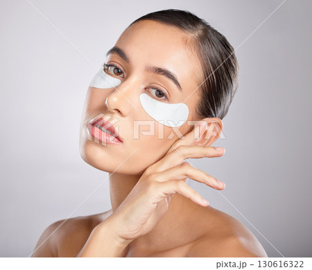 Skincare, eye patch and portrait of woman with beauty product for self care, anti aging and wellness. Facial healthcare, spa salon and aesthetic model face with makeup cosmetics on studio background Skincare, eye patch and portrait of woman with beauty product for self care, anti aging and wellness. Facial healthcare, spa salon and aesthetic model face with makeup cosmetics on studio background 130616322
