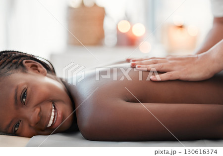 Black woman, smile and back massage at spa in relax for physical therapy, zen or stress relief at resort. Happy African American female smiling relaxing for healthy wellness, body care or treatment 130616374