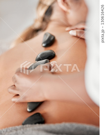 Woman, hands and rock on back in spa treatment for relaxation, stress relief or massage at resort. Hand of masseuse applying rocks to female in physical therapy skincare, body healing or wellness Woman, hands and rock on back in spa treatment for relaxation, stress relief or massage at resort. Hand of masseuse applying rocks to female in physical therapy skincare, body healing or wellness 130616426