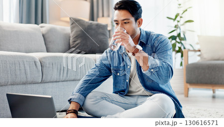Laptop, drinking water and man in home for remote work, reading report or news update on floor. Computer, thirsty freelancer and glass beverage in lounge, review headline and article for journalism Laptop, drinking water and man in home for remote work, reading report or news update on floor. Computer, thirsty freelancer and glass beverage in lounge, review headline and article for journalism 130616571