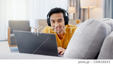Relax, laptop and portrait with man on sofa for streaming service, headphones and film. Movie subscription, media website and home cinema app with person in living room of apartment for online video 130616833