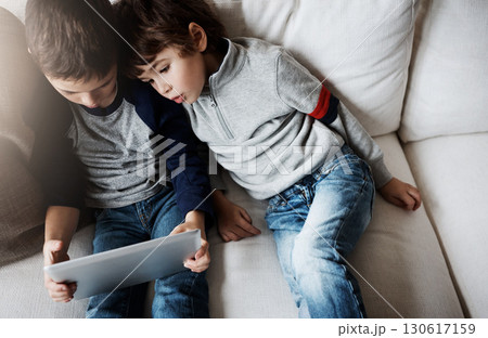 Top view, children or tablet for movie streaming, social media, or esports gaming on family home sofa. Curious kids, brothers or boys on digital technology for education app, learning support or help Top view, children or tablet for movie streaming, social media, or esports gaming on family home sofa. Curious kids, brothers or boys on digital technology for education app, learning support or help 130617159