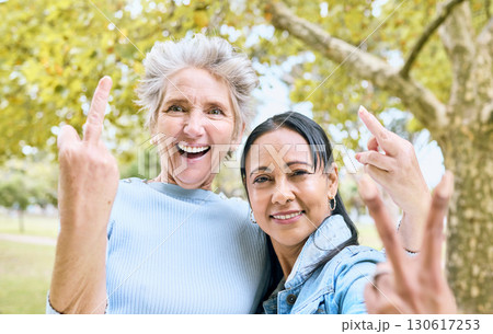Senior women, park portrait and hand sign for comic, funny and happy time together in nature. Old woman, friends and hands with peace, middle finger and laughing by trees, nature or forest to relax 130617253