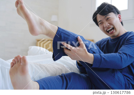 ベッドで足がつる20代男性 130617786