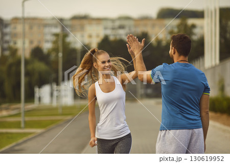 Woman Giving High Five to Male Coach During City Park Workout 130619952